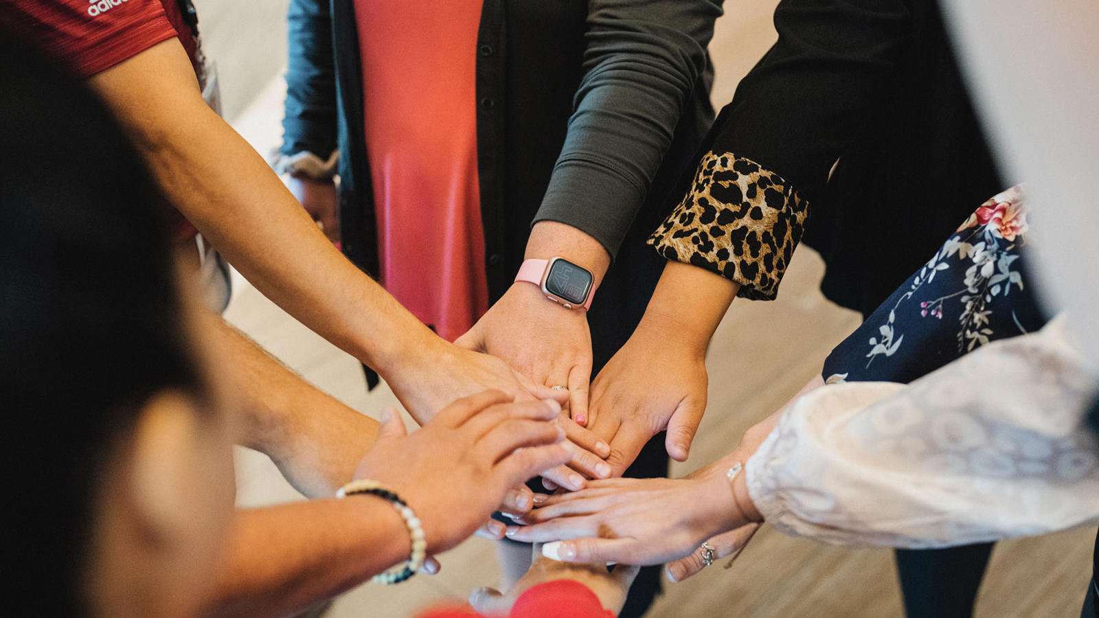 a group of people putting their hands together