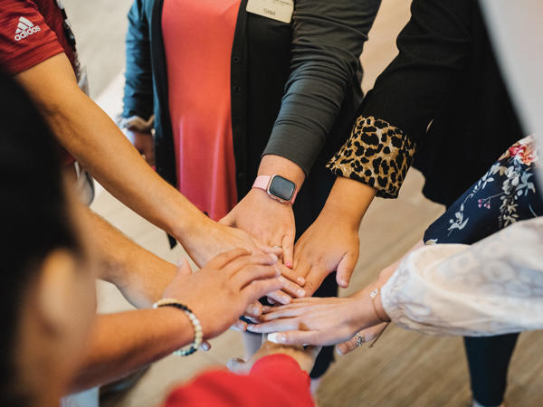 a group of people putting their hands together