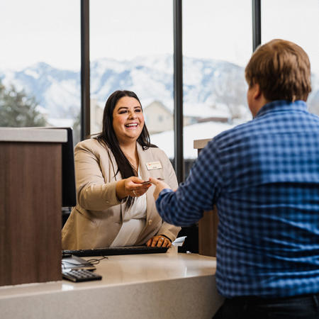 a person shaking hands with a person at a desk