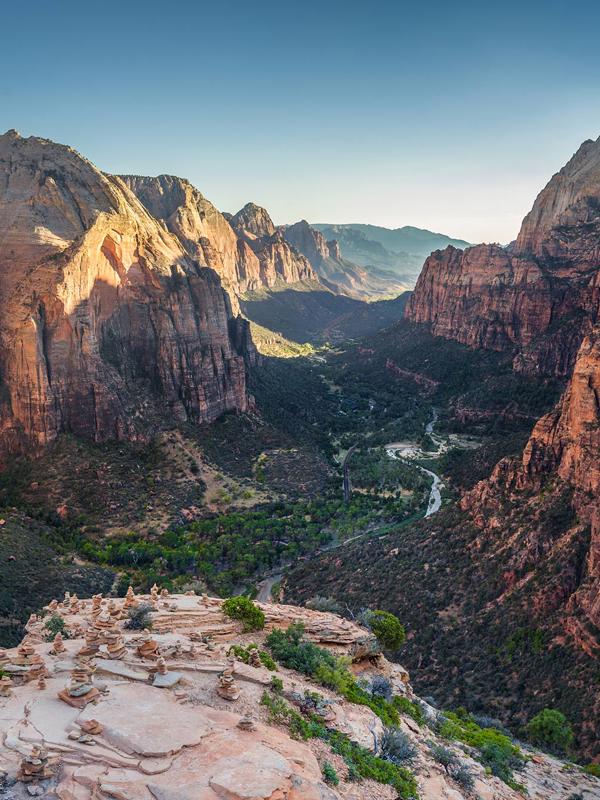a canyon with a river in the middle with Zion National Park in the background