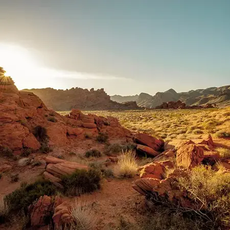a rocky landscape with a sun shining through