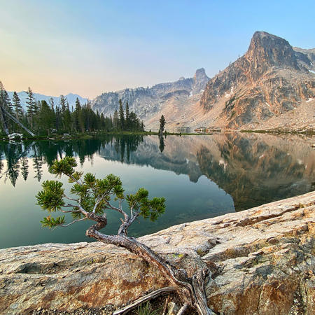 a lake with trees and mountains in the background
