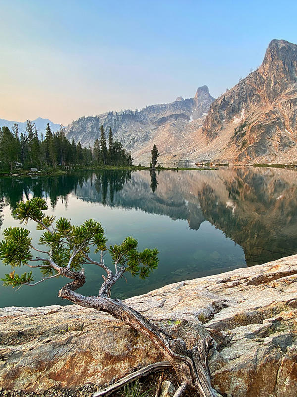 a lake with trees and mountains in the background